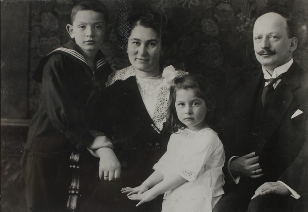 Das Familienporträt zeigt das sitzende Ehepaar Freund. Die beiden Kinder stehen neben der Mutter: Gisèles Hände liegen auf dem Schoß der Mutter, Hans hält sich am rechten Arm der Mutter fest.