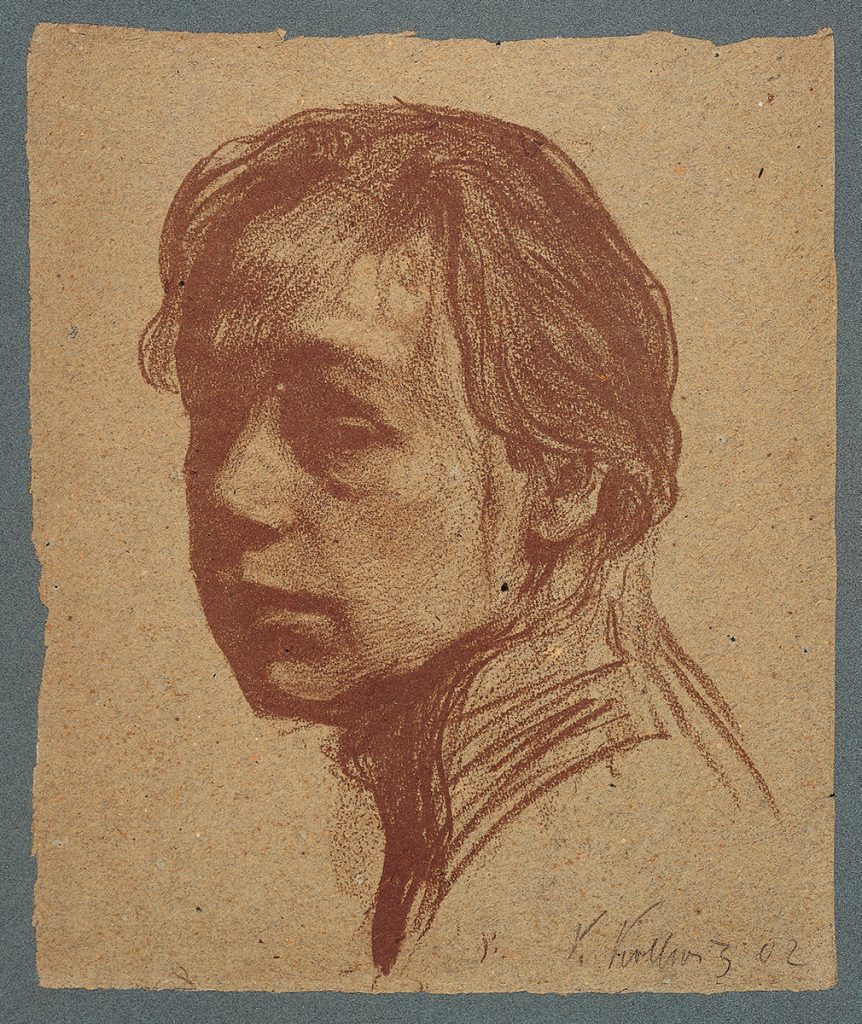 Selbstbildnis von Käthe Kollwitz im Dreiviertelprofil. Kopfstück. Der Blick ist melancholisch, auf einen imaginären Punkt außerhalb des Bildes gerichtet. Die rechte Gesichtshälfte ist verschattet. Während Haare und Gesicht detailliert ausgearbeitet sind, ist der Hals nur skizzenhaft angedeutet. Rechts unten signiert: K. Kollwitz